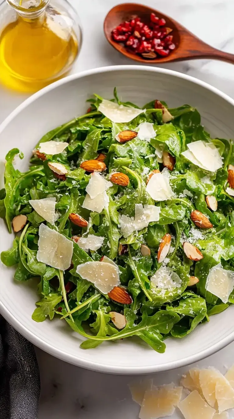 Fresh baby arugula salad topped with large shavings of Parmigiano-Reggiano and a lemon vinaigrette