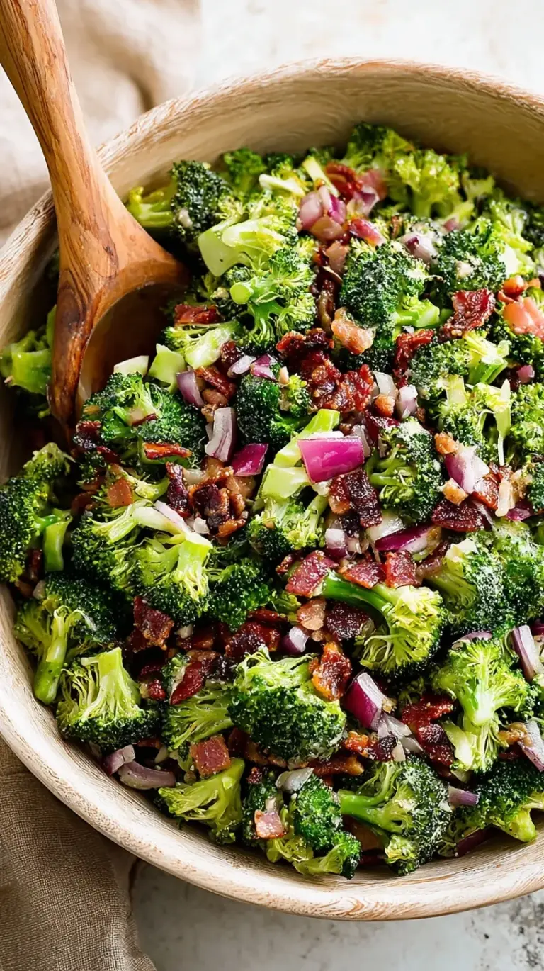 A bowl of creamy broccoli salad with bacon bits, red onions, and sunflower seeds