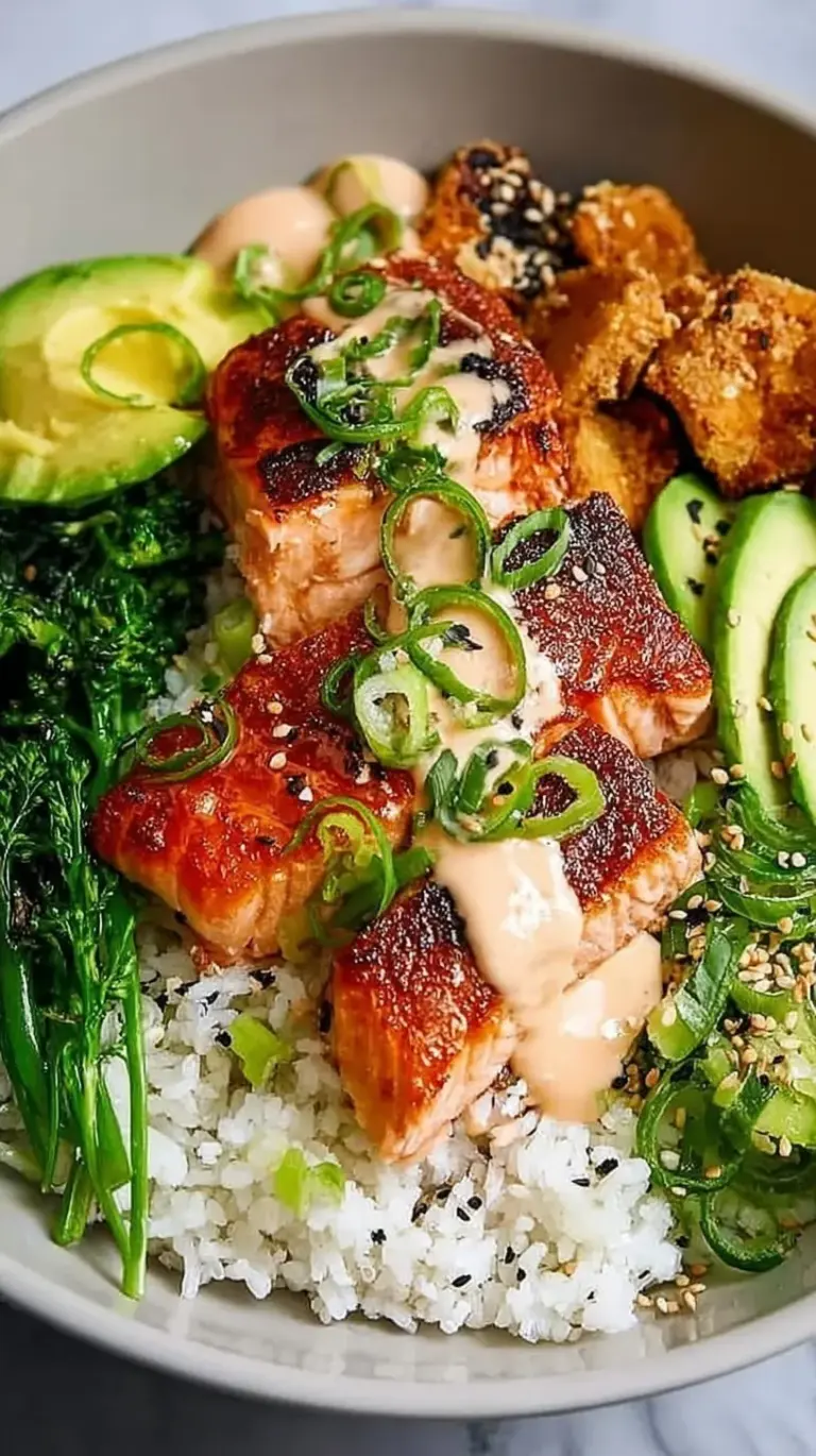 Two colorful Crispy Salmon Bowls topped with avocado and spicy mayo