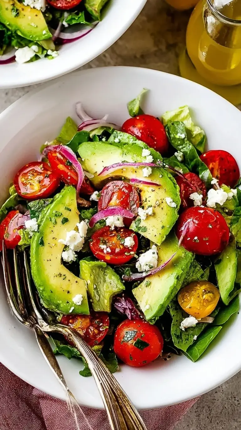 A vibrant bowl of cubed avocados, cherry tomatoes, red onions, and cilantro tossed in a lime dressing.