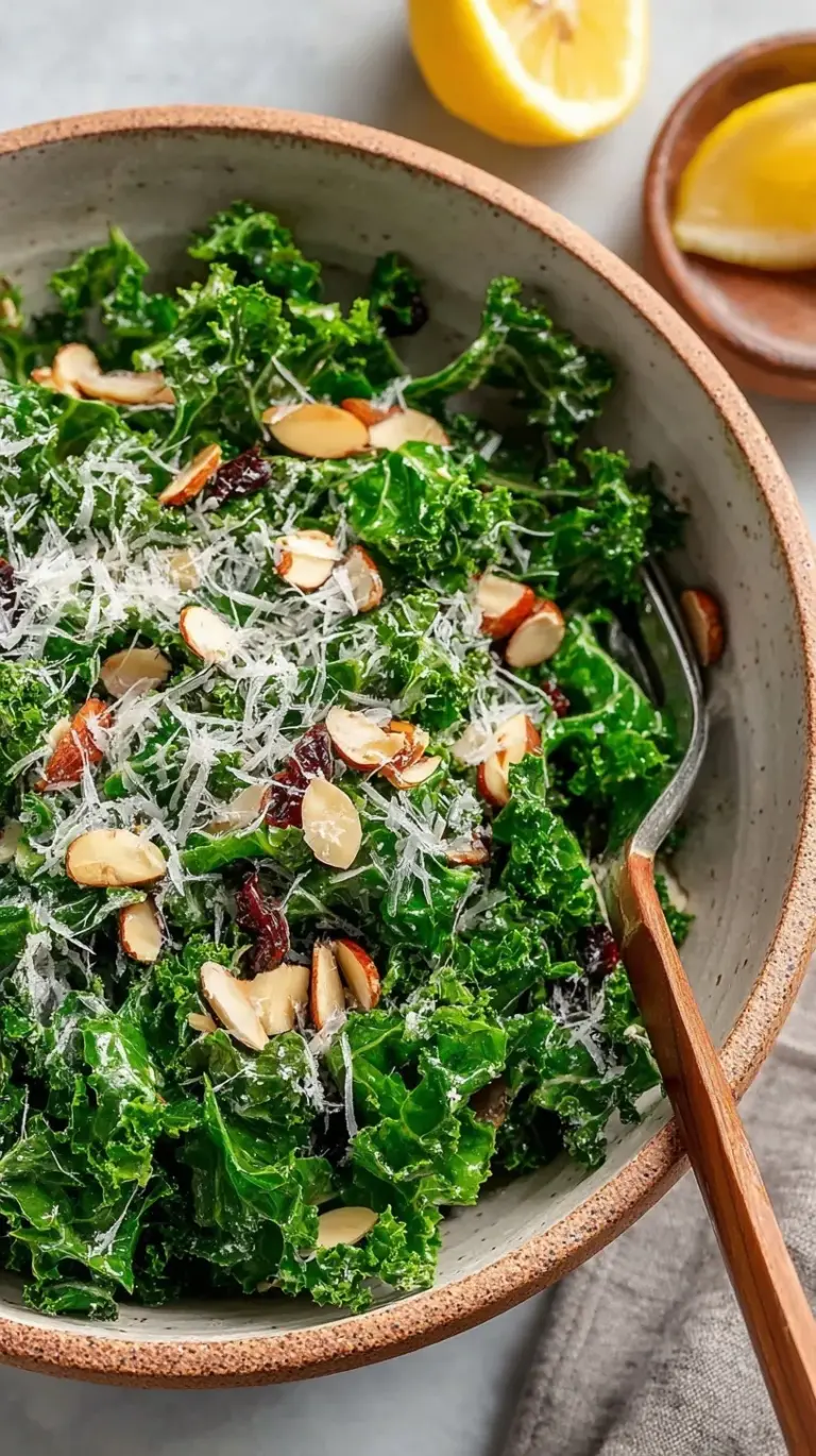 A vibrant bowl of massaged curly kale with dried cranberries, pumpkin seeds, and shaved parmesan cheese.