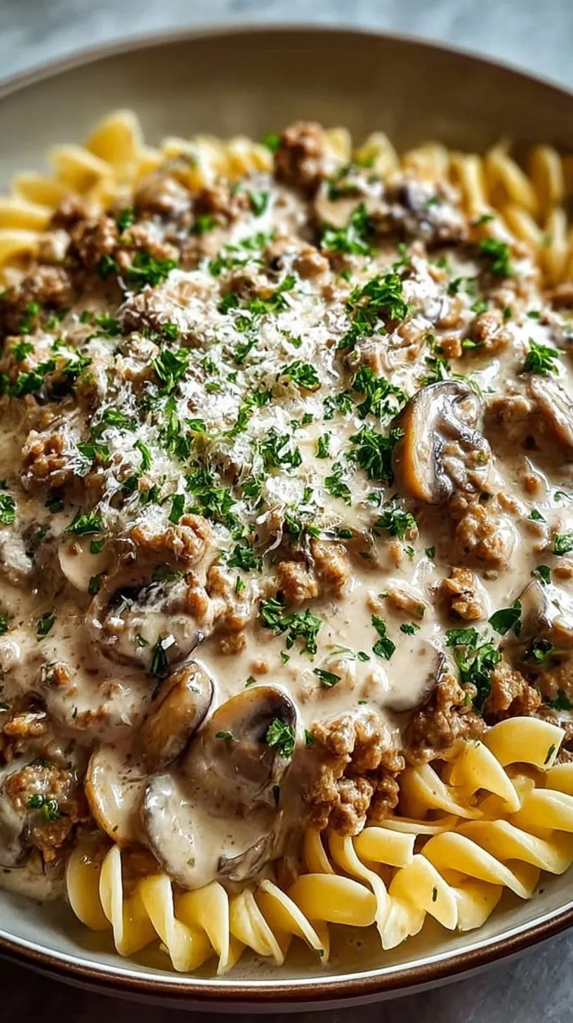 Creamy ground turkey stroganoff with mushrooms over egg noodles garnished with parsley
