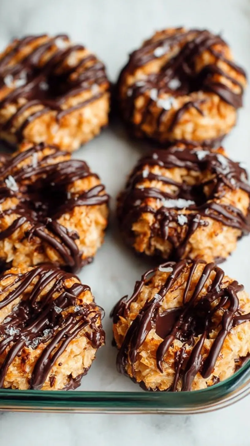 A stack of homemade Samoas cookies with toasted coconut, caramel, and chocolate drizzle on a cooling rack.