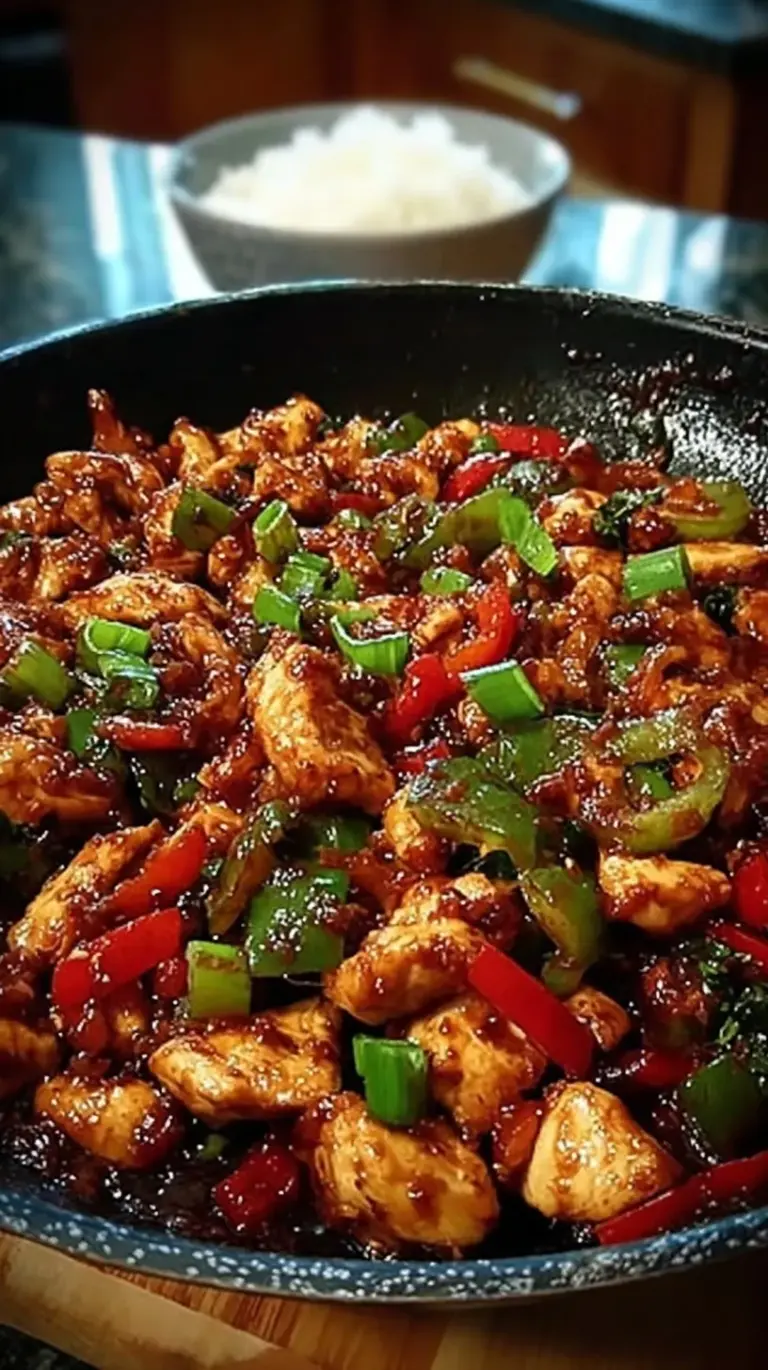 A steaming skillet of Korean Spicy Chicken Stir Fry with cabbage, sweet potatoes, and rice cakes in a red gochujang sauce.