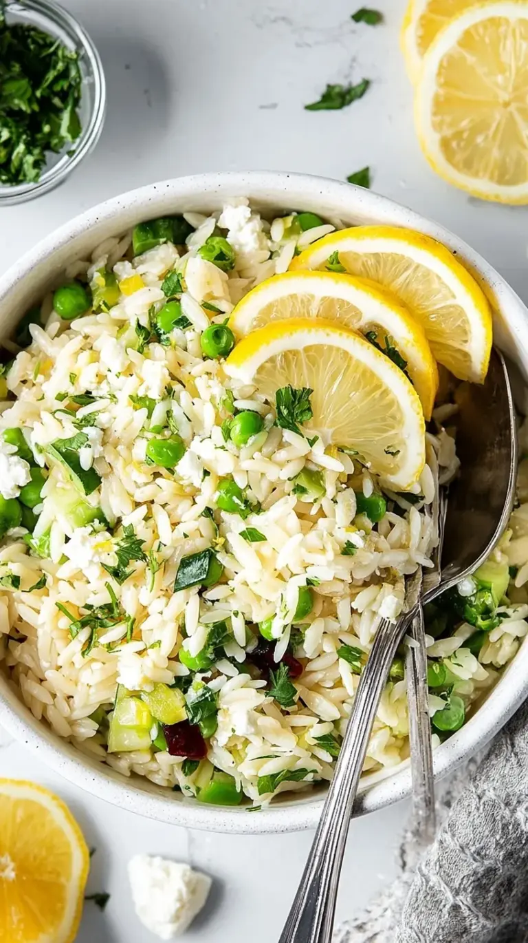 A vibrant bowl of lemon orzo salad with cherry tomatoes, cucumbers, and feta cheese