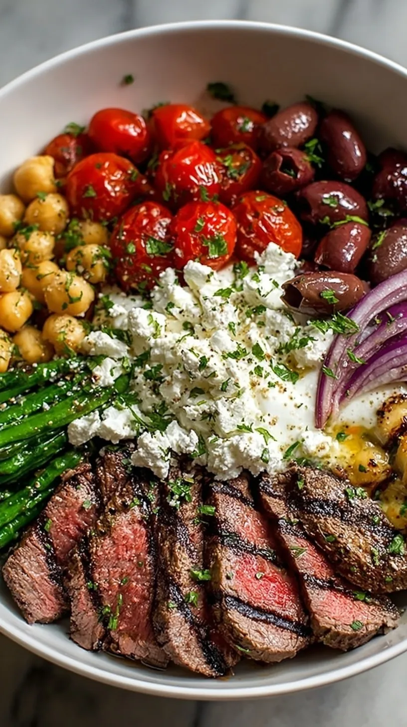 A vibrant Mediterranean Steak Bowl with sliced flank steak, quinoa, tomatoes, cucumbers, and feta cheese.