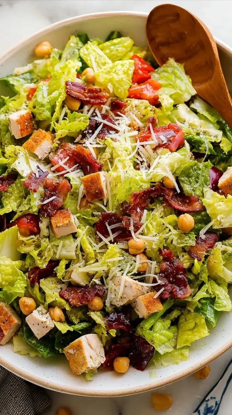 A vibrant Jennifer Aniston Salad in a white bowl featuring bulgur, chickpeas, herbs, and pistachios