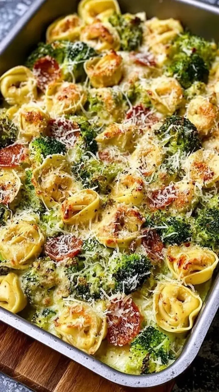 Golden toasted cheese tortellini and roasted broccoli on a sheet pan with melted mozzarella.