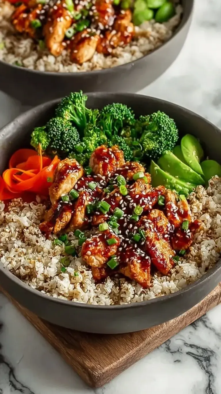 A bowl of sticky glazed chicken over white rice with steamed broccoli and green onions